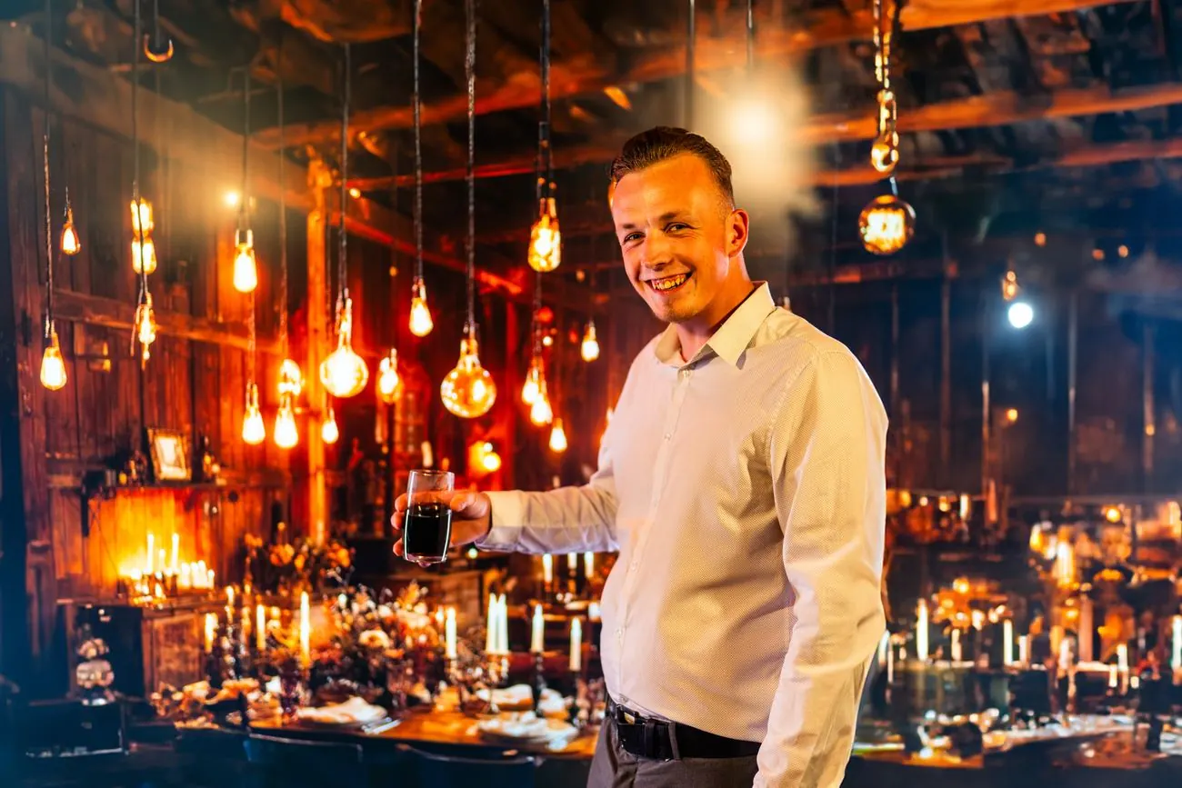 Nick Baumgarten in einer Location mit warmen Lichterketten